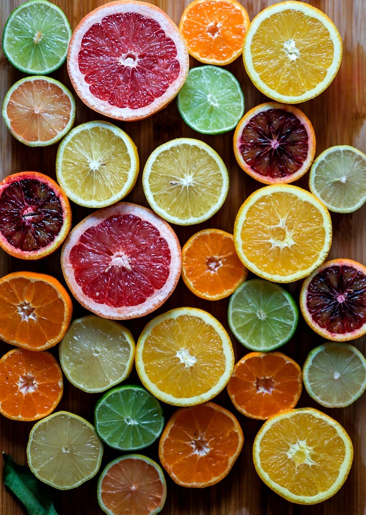assorted sliced citrus fruits on brown wooden chopping board
